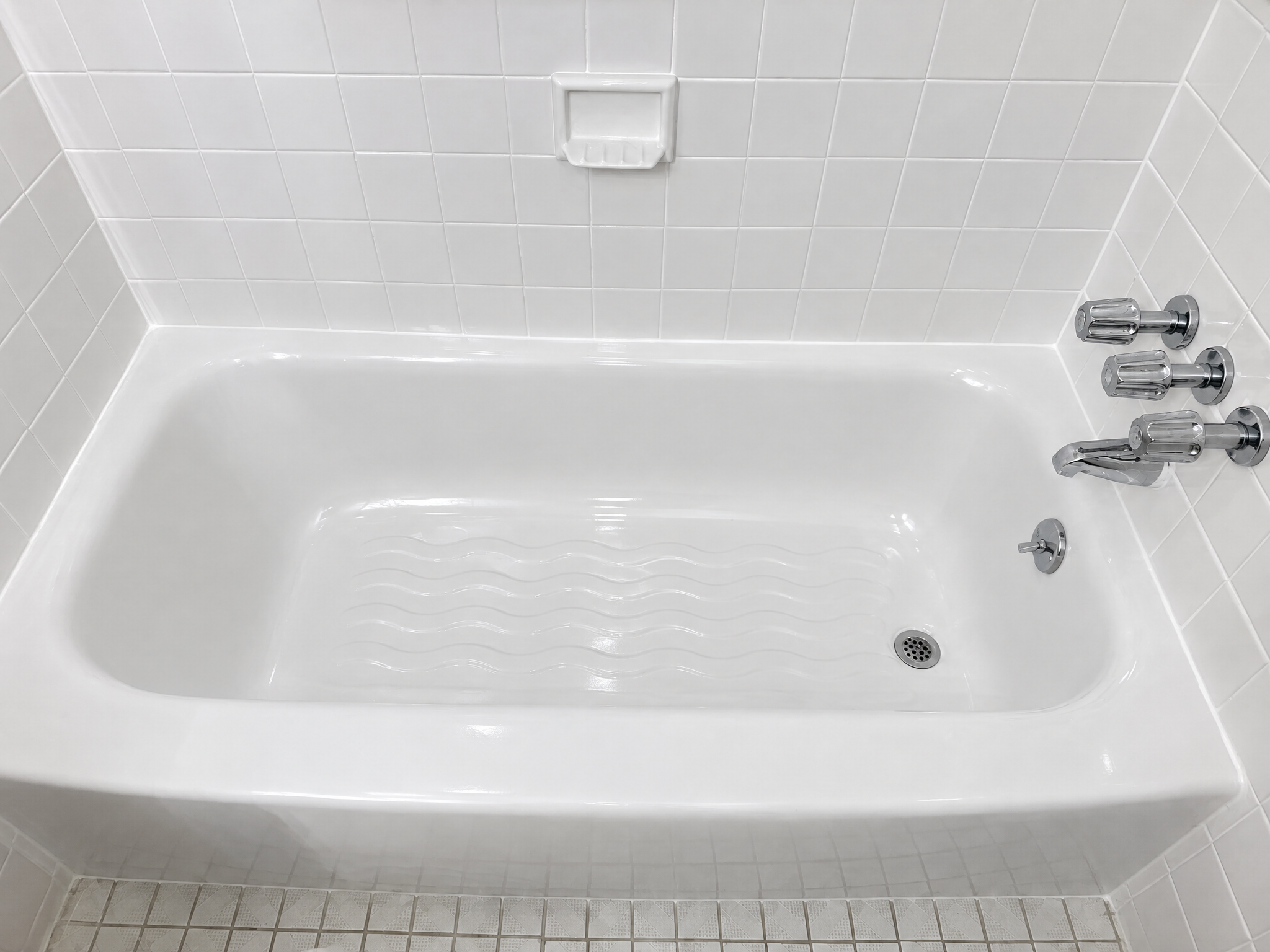 Bathtub after professional reglazing - clean white finish